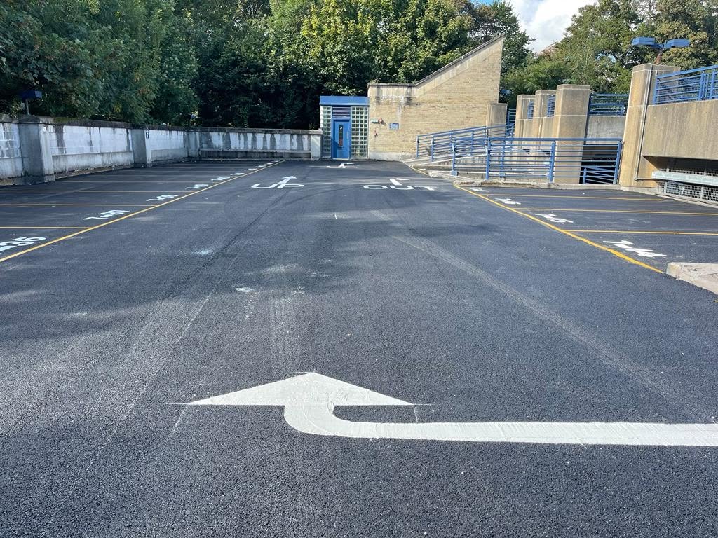 Newly laid tarmac with turn arrow marking on a car park deck