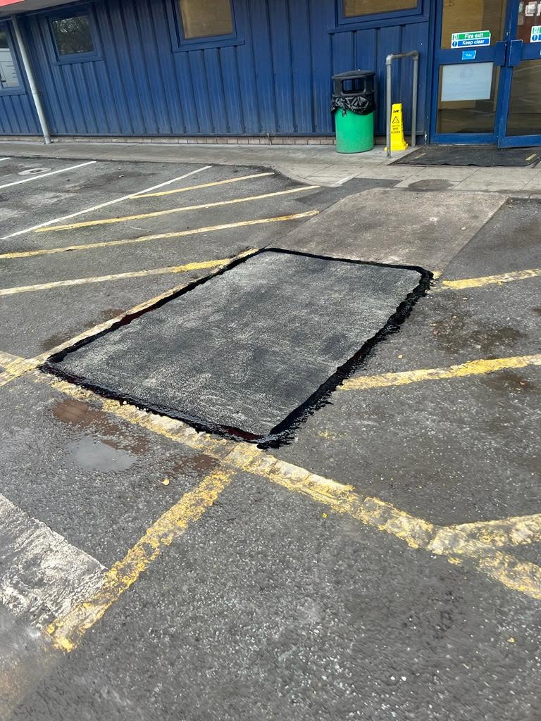 Tarmac patch repair beside yellow line marking