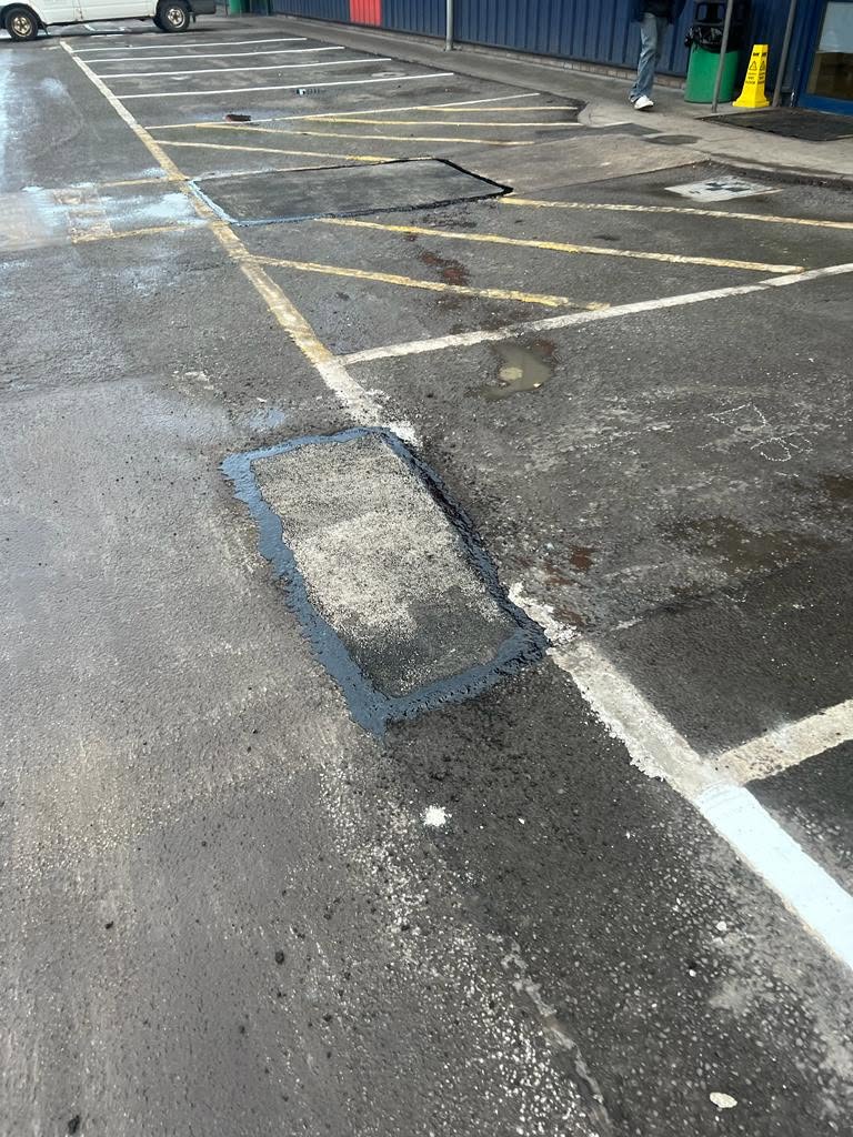 Tarmac patch repair beside white line marking