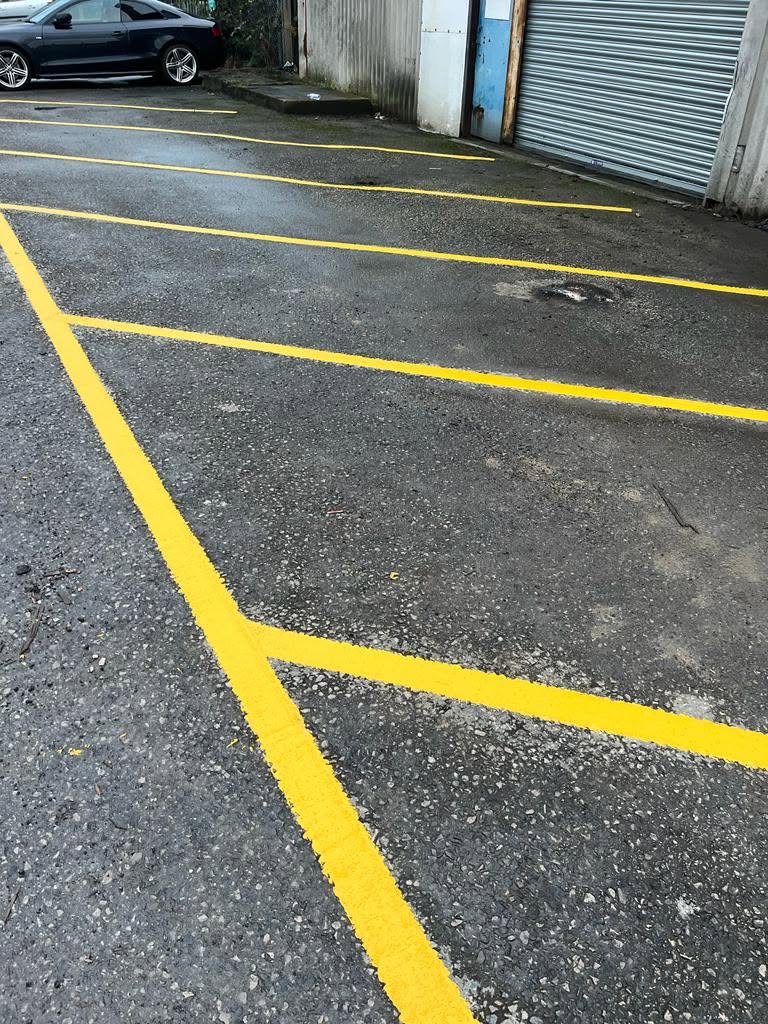 Fresh yellow line marking on a resurfaced car park